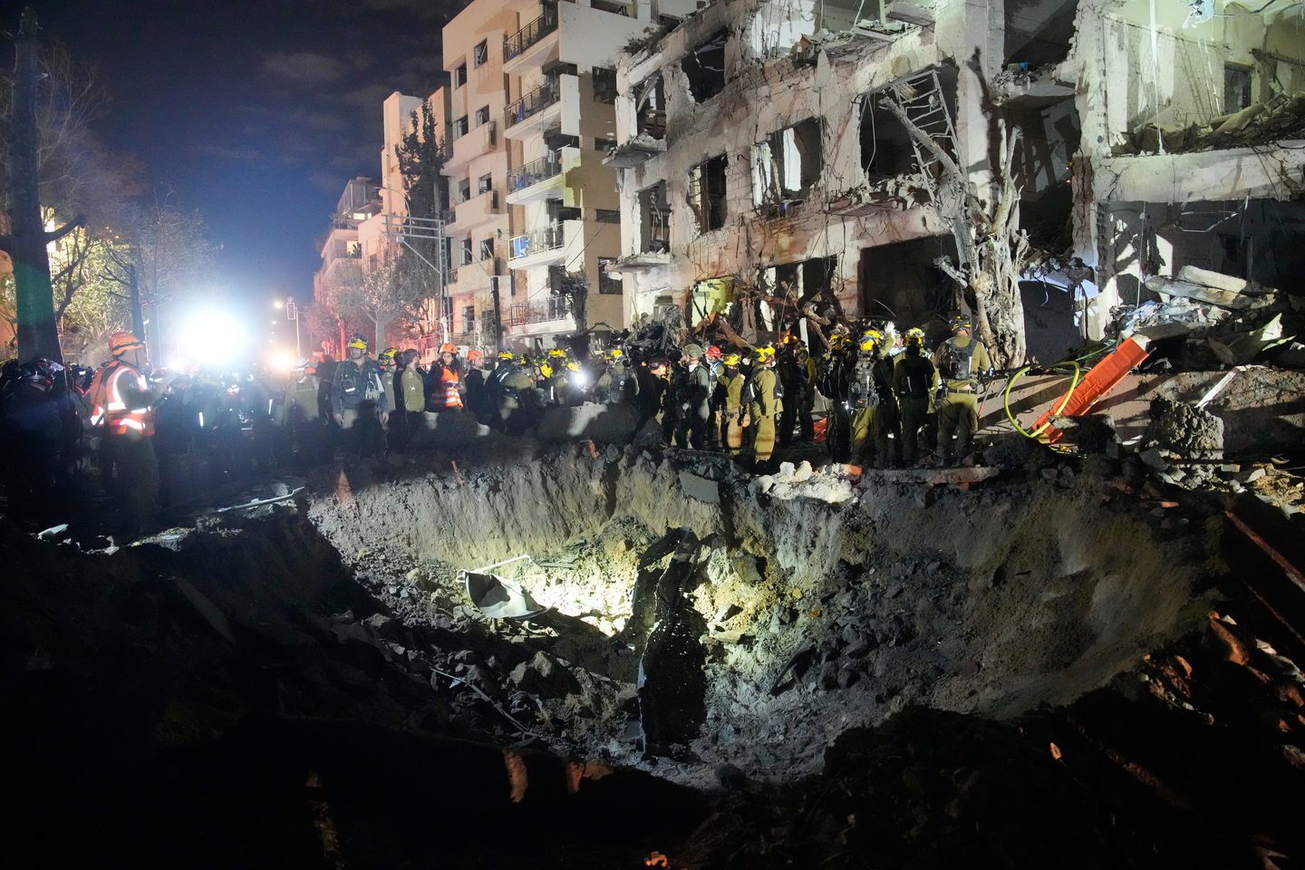 Officers from Israel's Home Front Command search through the rubble of a damaged apartment building after an Iranian missile strike, in Tel Aviv, Israel, on March 1. [AP/YONHAP]