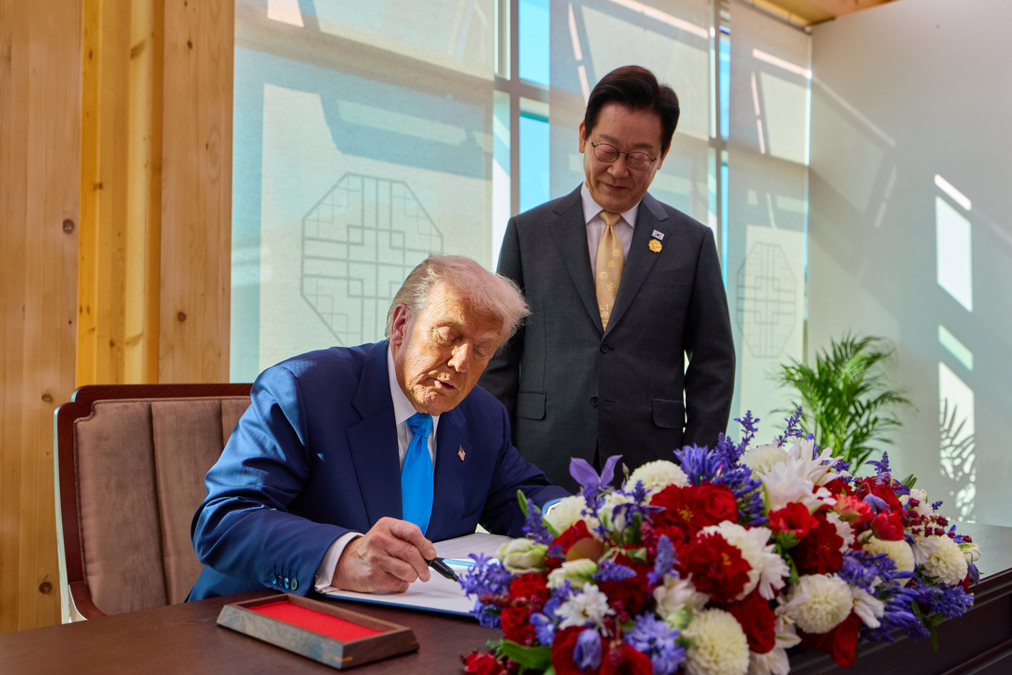 President Lee Jae Myung, right, watches U.S. President Donald Trump sign a guest book at the Gyeongju National Museum in North Gyeongsang ahead of their bilateral summit on Oct. 29, 2025. [PRESIDENTIAL OFFICE]