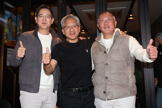 Nvidia CEO Jensen Huang, center, takes a photo with Samsung Electronics Executive Chairman Lee Jae-yong, left, and Hyundai Motor Group Executive Chair Euisun Chung during a dinner in a chicken restaurant in southern Seoul on Oct. 30, 2025. [JOINT PRESS CORPS]