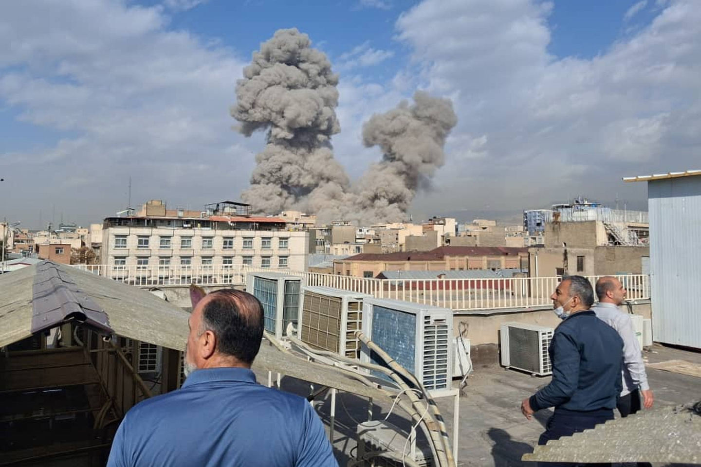 People watch as smoke rises on the skyline after an explosion in Tehran, Iran, on Feb. 28. [AP/YONHAP]