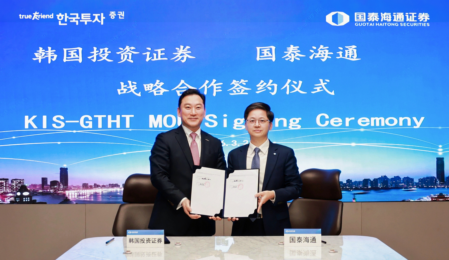 Kim Sung-hwan, president of Korea Investment & Securities, left, and Li Junjie, president of Guotai Haitong Securities, pose for a photo during a signing ceremony held at Guotai Haitong Securities' headquarters in Shanghai on March 2. [KOREA INVESTMENT & SECURITIES]