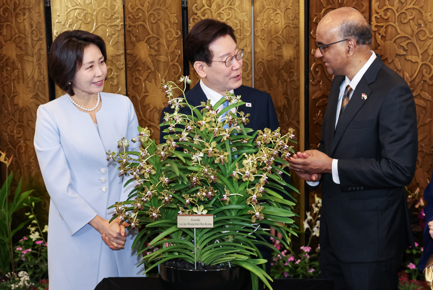 President Lee Jae Myung, center, and first lady Kim Hea Kyung, left, attend a ceremony naming an orchid hybrid after them, hosted by Singaporean President Tharman Shanmugaratnam, right, at the Foreign Ministry in Singapore on March 2. [JOINT PRESS CORPS]