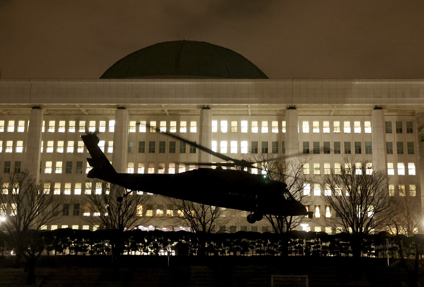 A military helicopter carrying martial law troops lands on the grounds of the National Assembly in Yeouido, Seoul, early on Dec. 4, 2024, after President Yoon Suk Yeol declared emergency martial law in a televised address to the nation the night before. [JUN MIN-KYU]