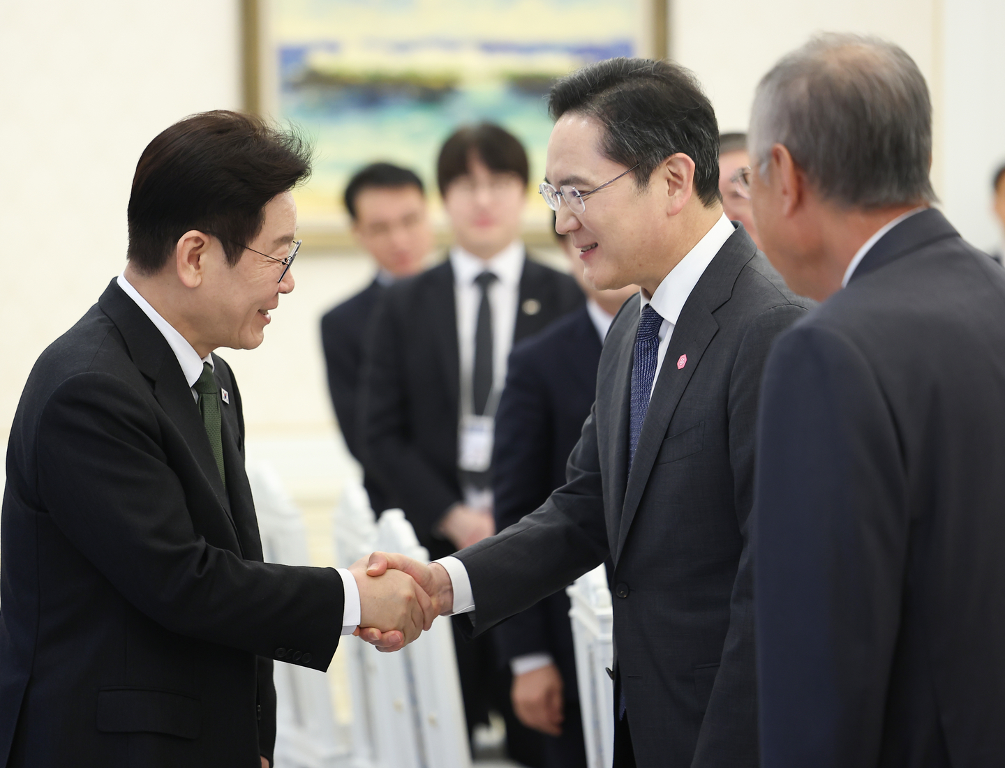 President Lee Jae Myung, left, shakes hands with by Samsung Electronics Executive Chairman Lee Jae-yong during a meeting with leaders of 10 major conglomerates at the Blue House in central Seoul on Feb. 4. [JOINT PRESS CORPS]
