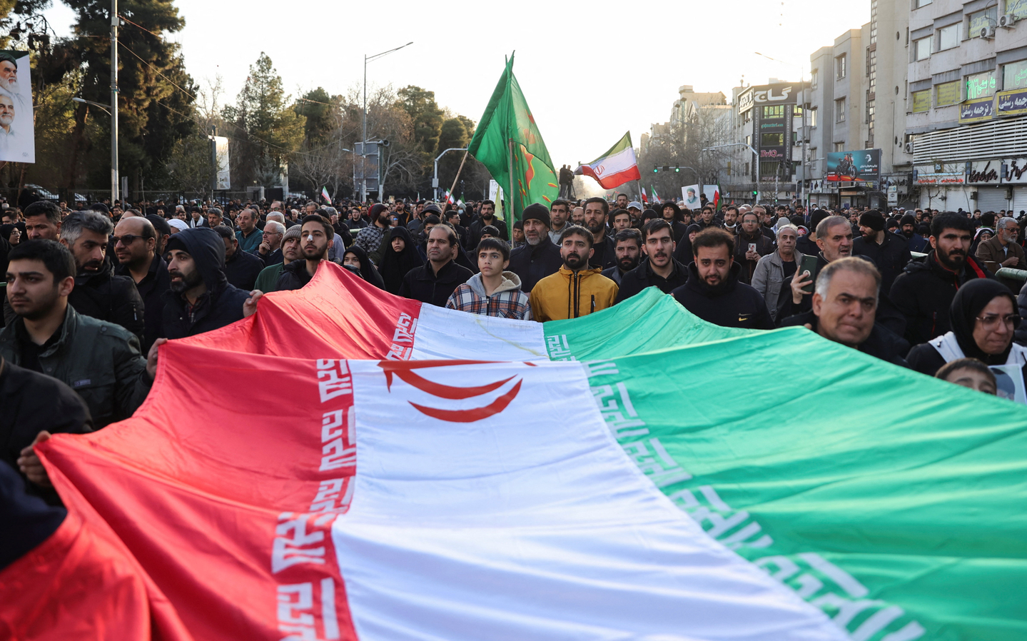 People carry a large Iranian flag as they gather after Iran's Supreme Leader Ayatollah Ali Khamenei was killed in Israeli and U.S. strikes in Tehran, Iran on March 1. [REUTERS/YONHAP]