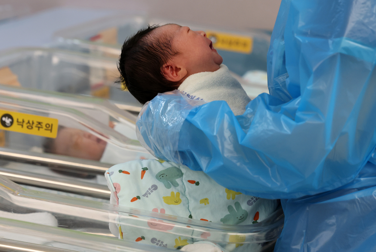 A nurse looks over a newborn in a nursery room at CHA Ilsan Medical Center in Goyang, Gyeonggi, on Nov. 26, 2025. [YONHAP]