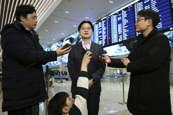 Industry Minister Kim Jung-kwan, center, takes reporters' questions at Incheon International Airport on Jan. 31. [YONHAP]