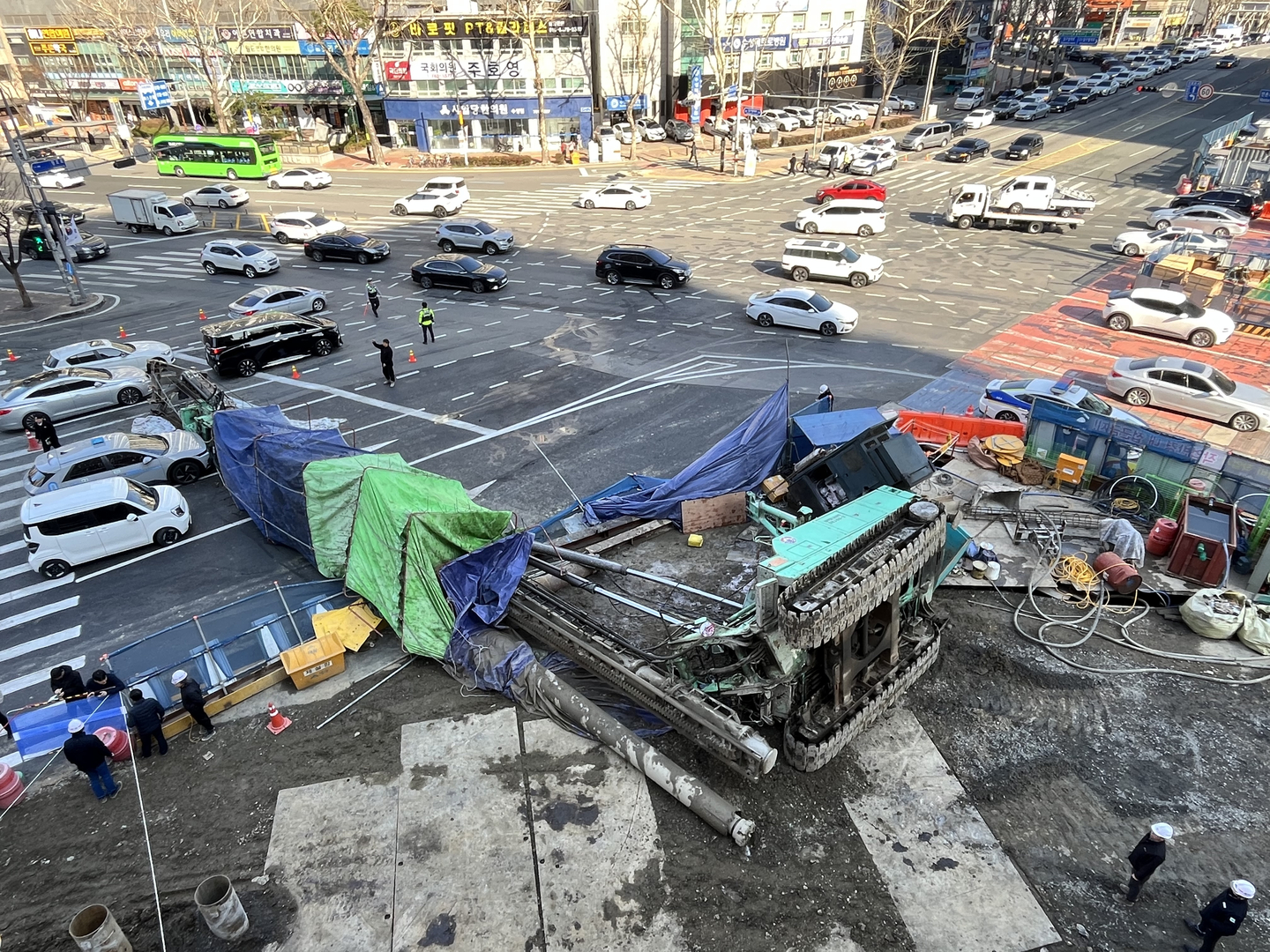 Police control traffic at the scene where a drilling rig fell and made contact with a passing taxi at Manchon Intersection in Suseong District, Daegu, on March 4, injuring three people including the driver. [NEWS1]