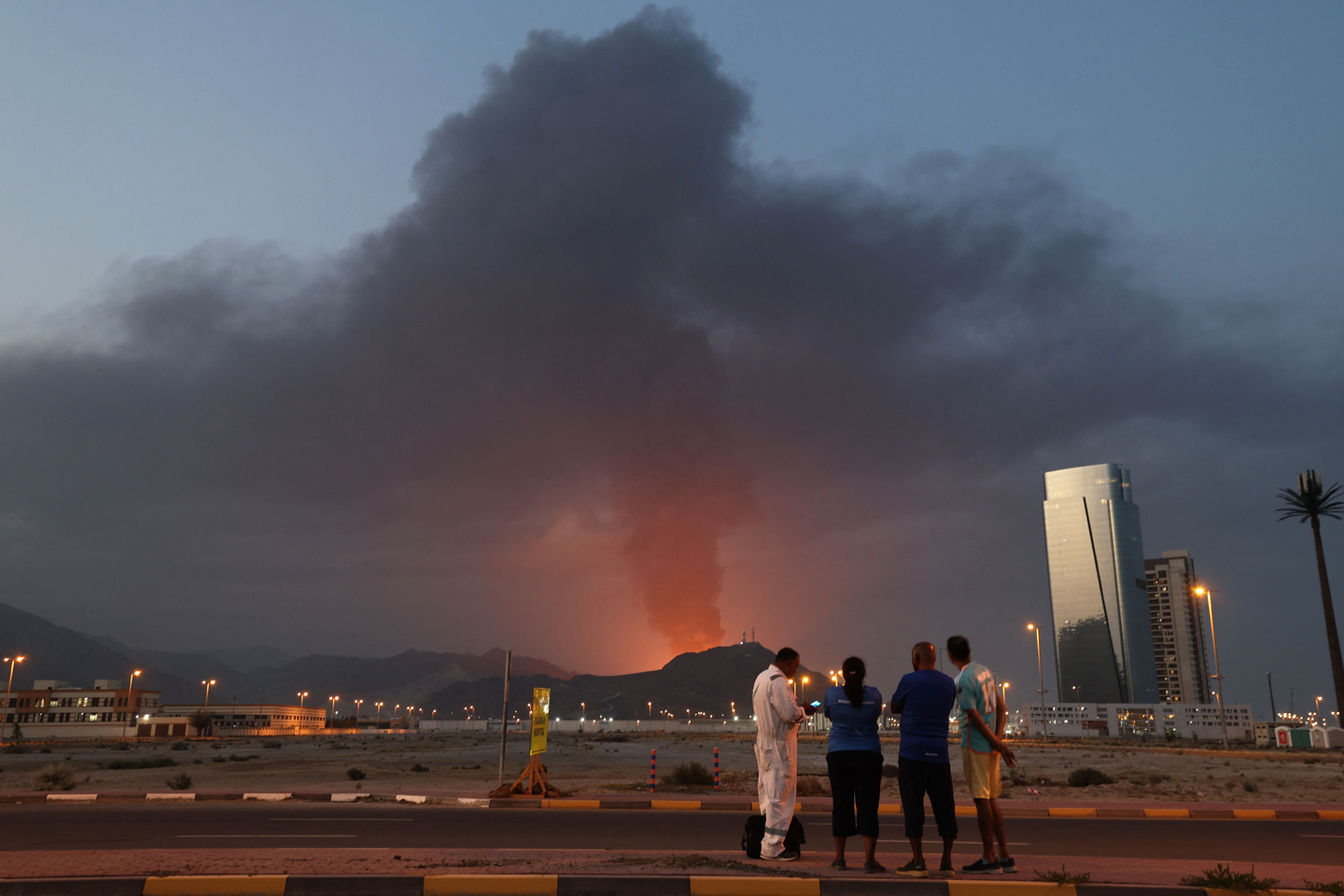 People look at a tall plume of black smoke following an explosion in the Fujairah industrial zone in the eastern coastal city of the same name in the United Arab Emirates on March 3. [AFP/YONHAP] 