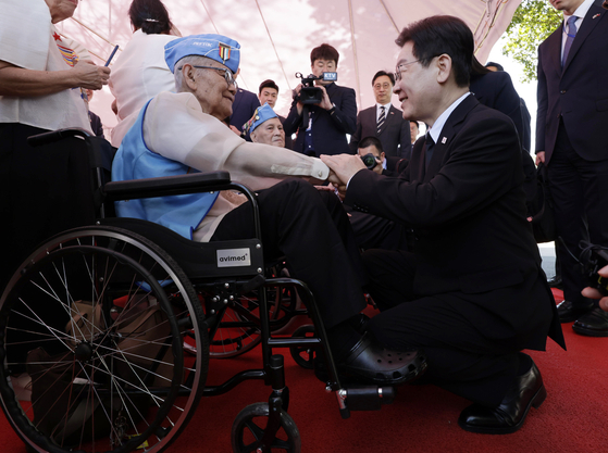 President Lee Jae Myung, right, holds the hand of a Philippine veteran who fought in the 1950-53 Korean War during his visit to the Korean War Memorial Pylon in the Libingan ng mga Bayani in Manila on March 4. [YONHAP]