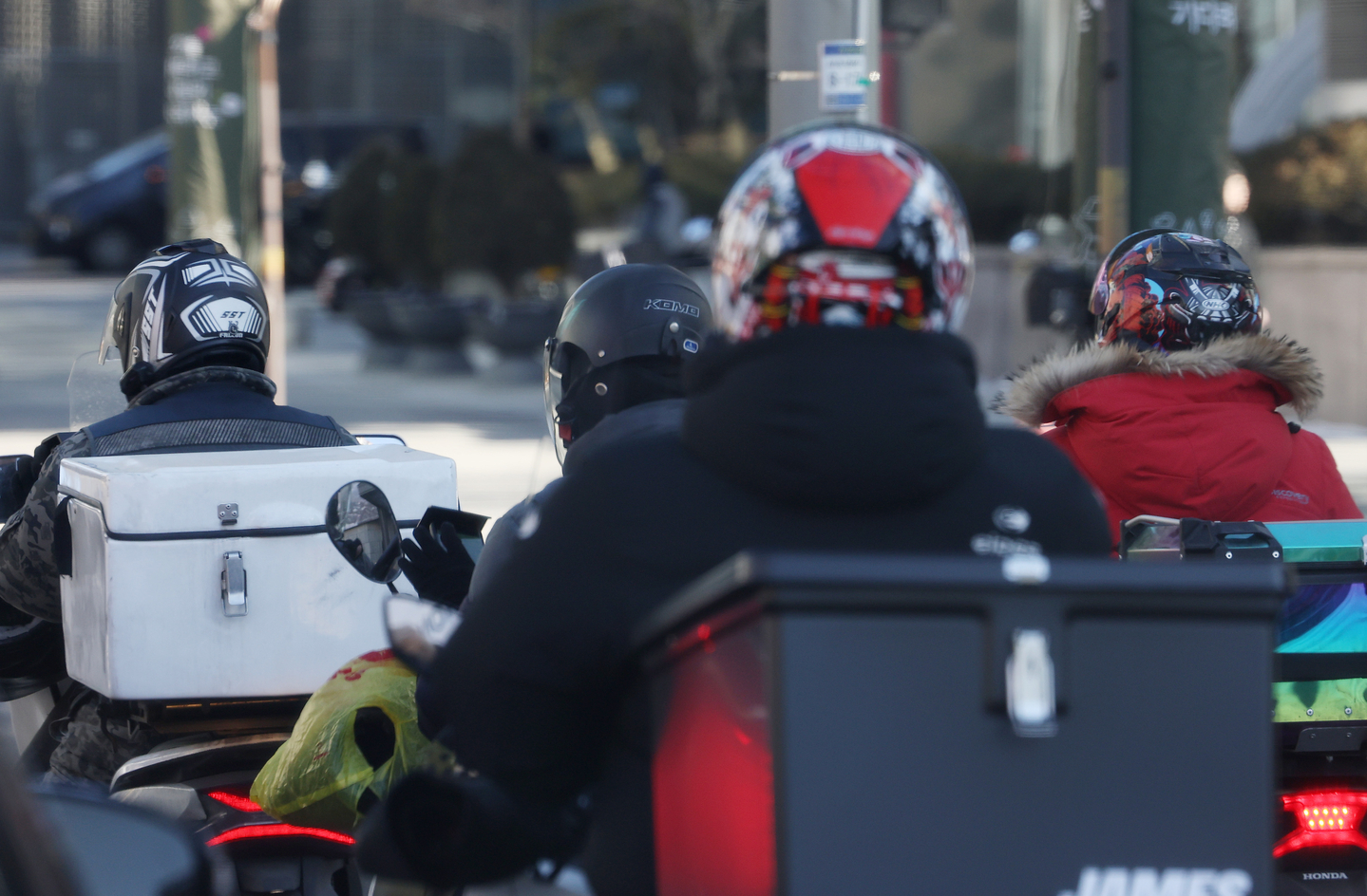 Delivery riders move on a street in Seoul on Jan. 22. [YONHAP] 