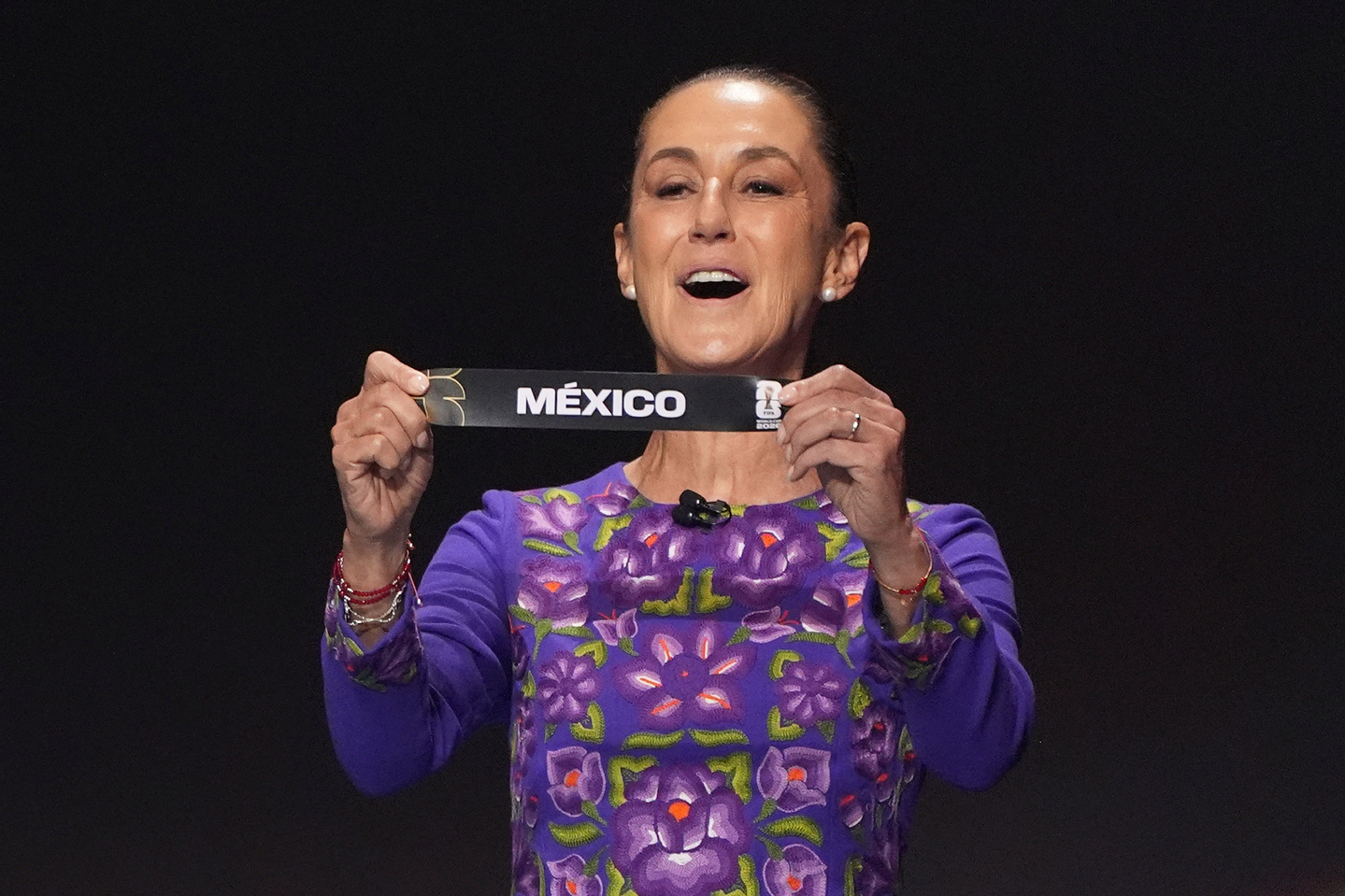 Mexican President Claudia Sheinbaum holds up a slip with "Mexico" during the draw for the 2026 FIFA World Cup at the Trump-Kennedy Center in Washington, Friday, Dec. 5, 2025. [AP/YONHAP]