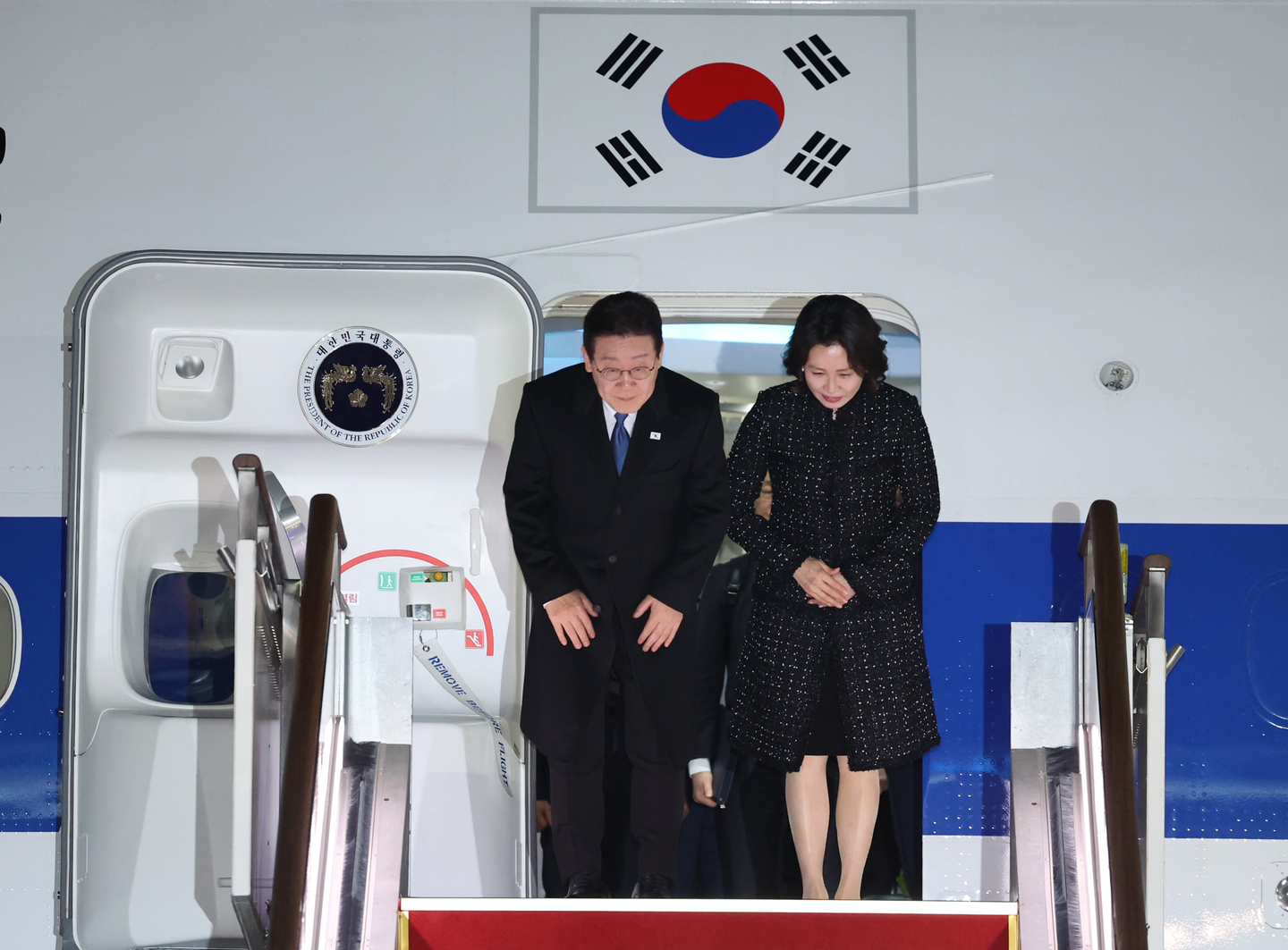 President Lee Jae Myung, left, and first lady Kim Hea Kyung offer greetings upon their arrival at Seoul Air Base in Seongnam, Gyeonggi, on March 4, after returning from their trip to Singapore and the Philippines. [YONHAP] 