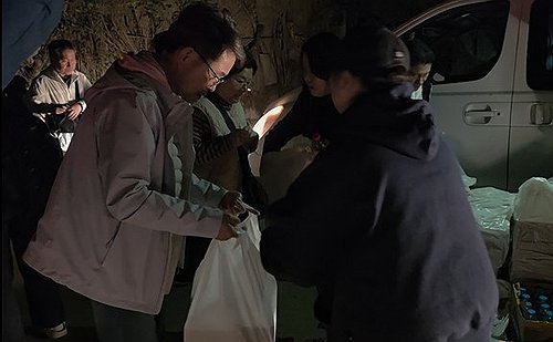 A Korean national, who evacuated from Israel, receives a bag of food from a Korean official in Cairo, Egypt, on March 4. [YONHAP] 