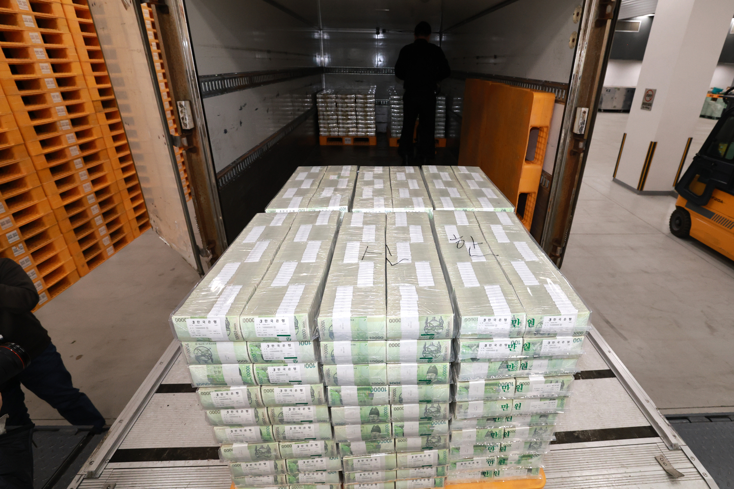 Employees move cash supplies to be distributed to commercial banks at the Bank of Korea headquarters in Jung District, central Seoul on Feb. 11. [YONHAP]