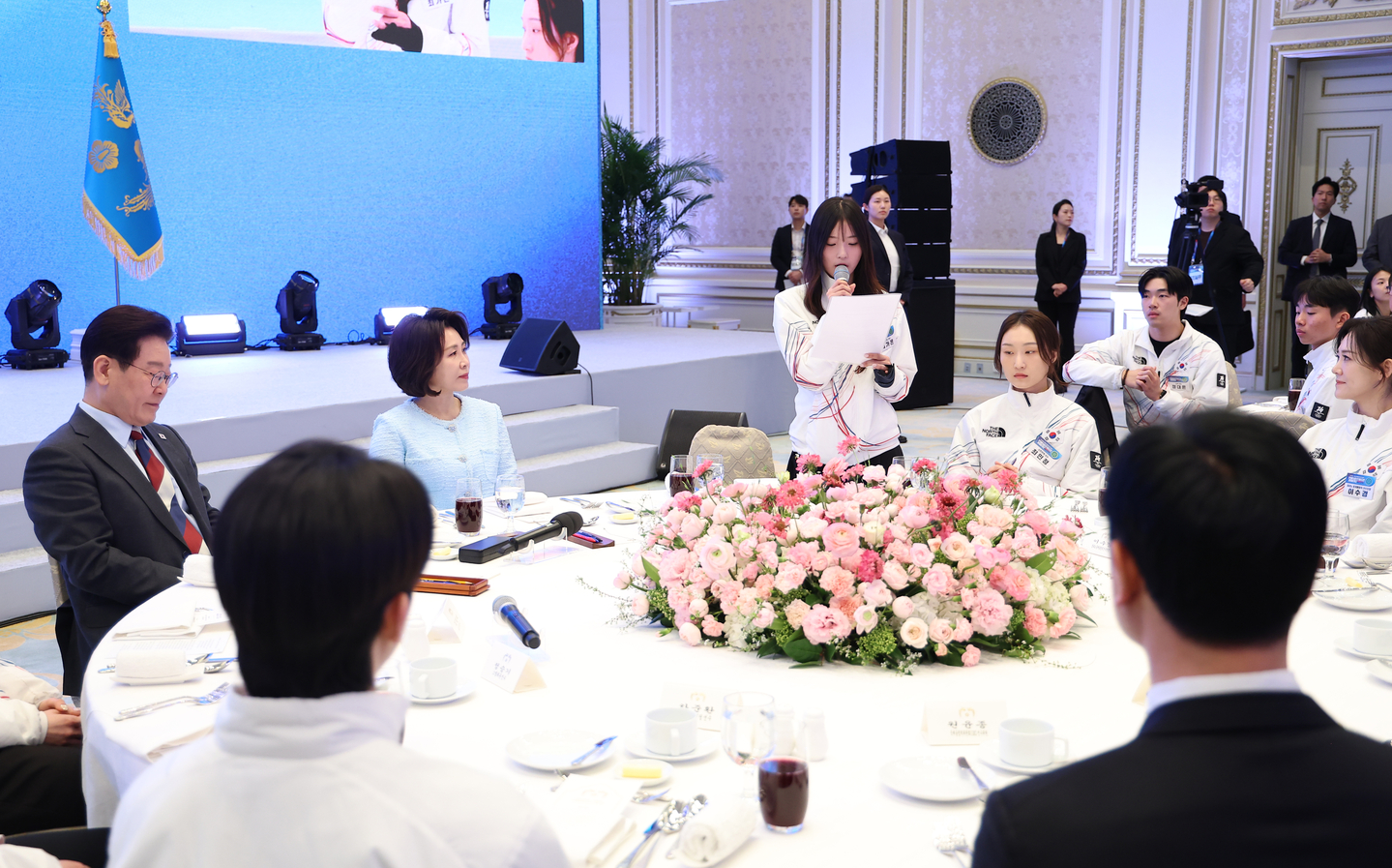Olympic snowboard gold medalist Choi Ga-on, center standing, speaks during a luncheon hosted by President Lee Jae Myung to congratulate the Korean national team, which competed in the 2026 Milan-Cortina Winter Olympics, at the state guesthouse of the Blue House in Jongno District, central Seoul, on March 5. [YONHAP]