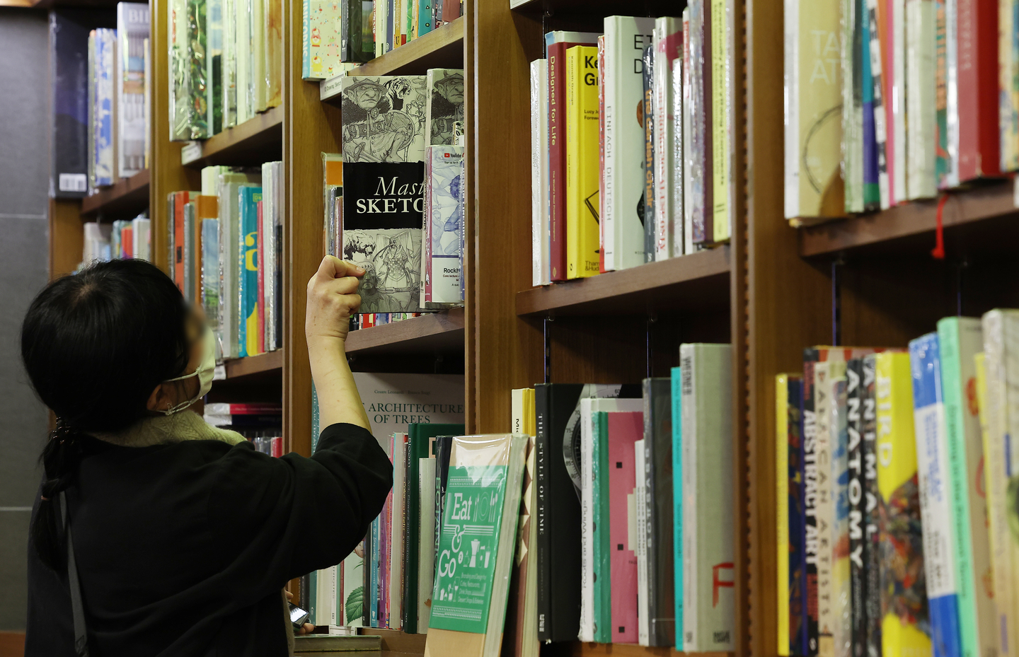 A customer chooses a book at a bookstore in Seoul on Nov. 13, 2025. [YONHAP]