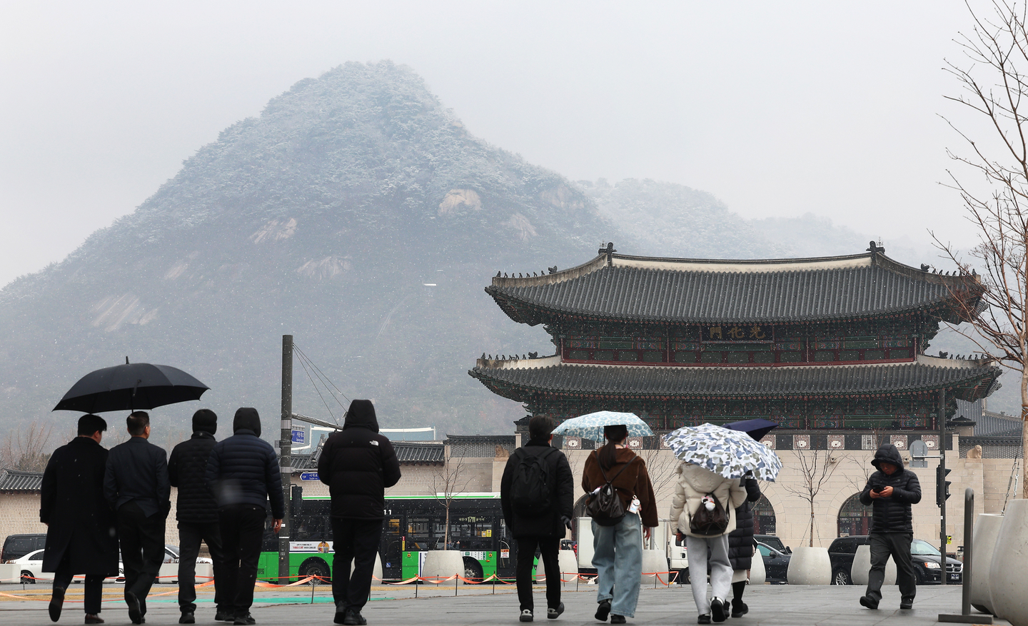 Pedestrians walk through sleet in Gwanghwamun Square in Jongno District, central Seoul, on March 6. [YONHAP]