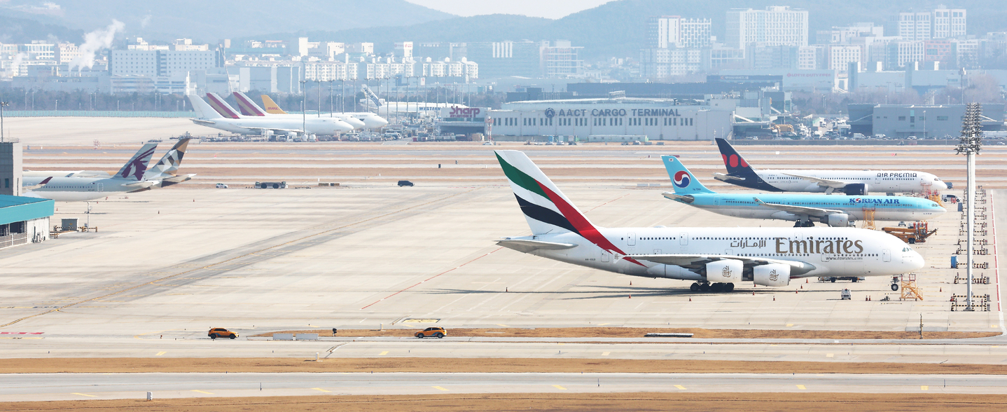 Passenger planes from airlines including Emirates and Qatar Airways stand on the apron at Incheon International Airport on March 5. [YONHAP] 