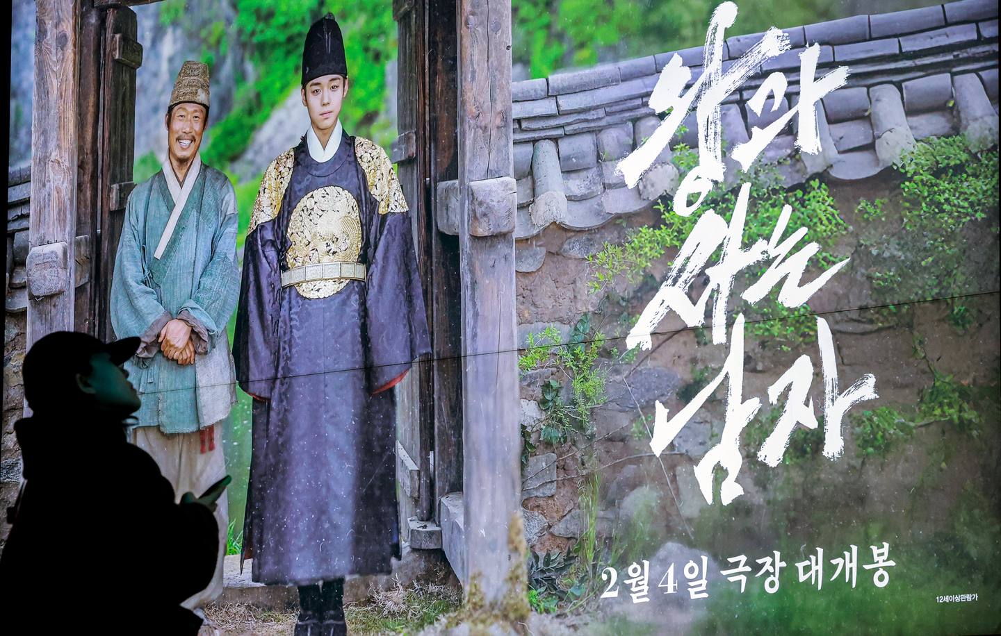 A moviegoer walks by a poster of the movie ″The King's Warden″ at a theater in Seoul on March 6. [NEWS1]