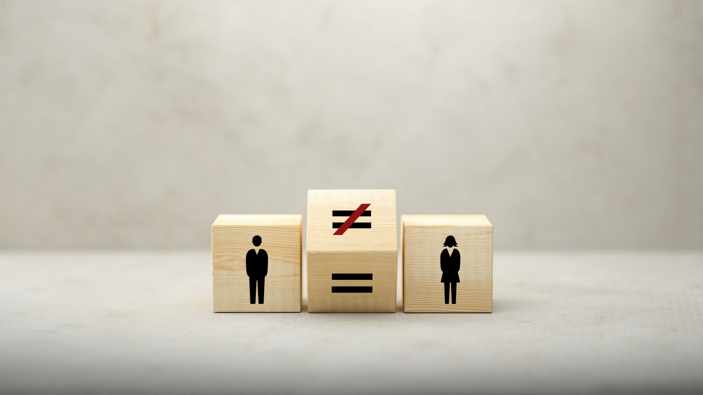 Male and female icons separated by a revolving equals signs on wooden cubes [GETTY IMAGES BANK]