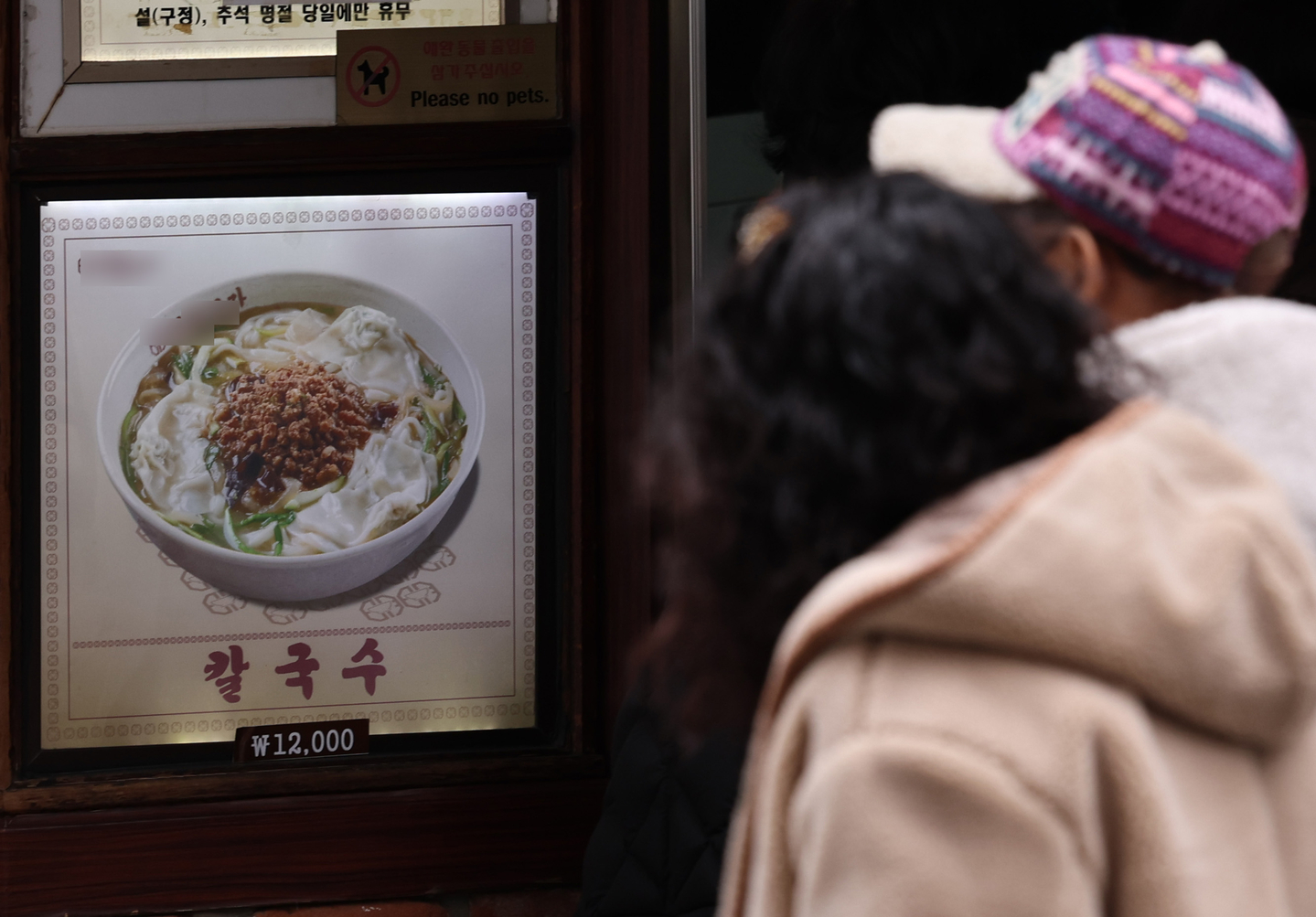 A sign showing the price of a bowl of noodle soup is seen posted outside a restaurant in Myeongdong, central Seoul, on Feb. 24. [NEWS1]