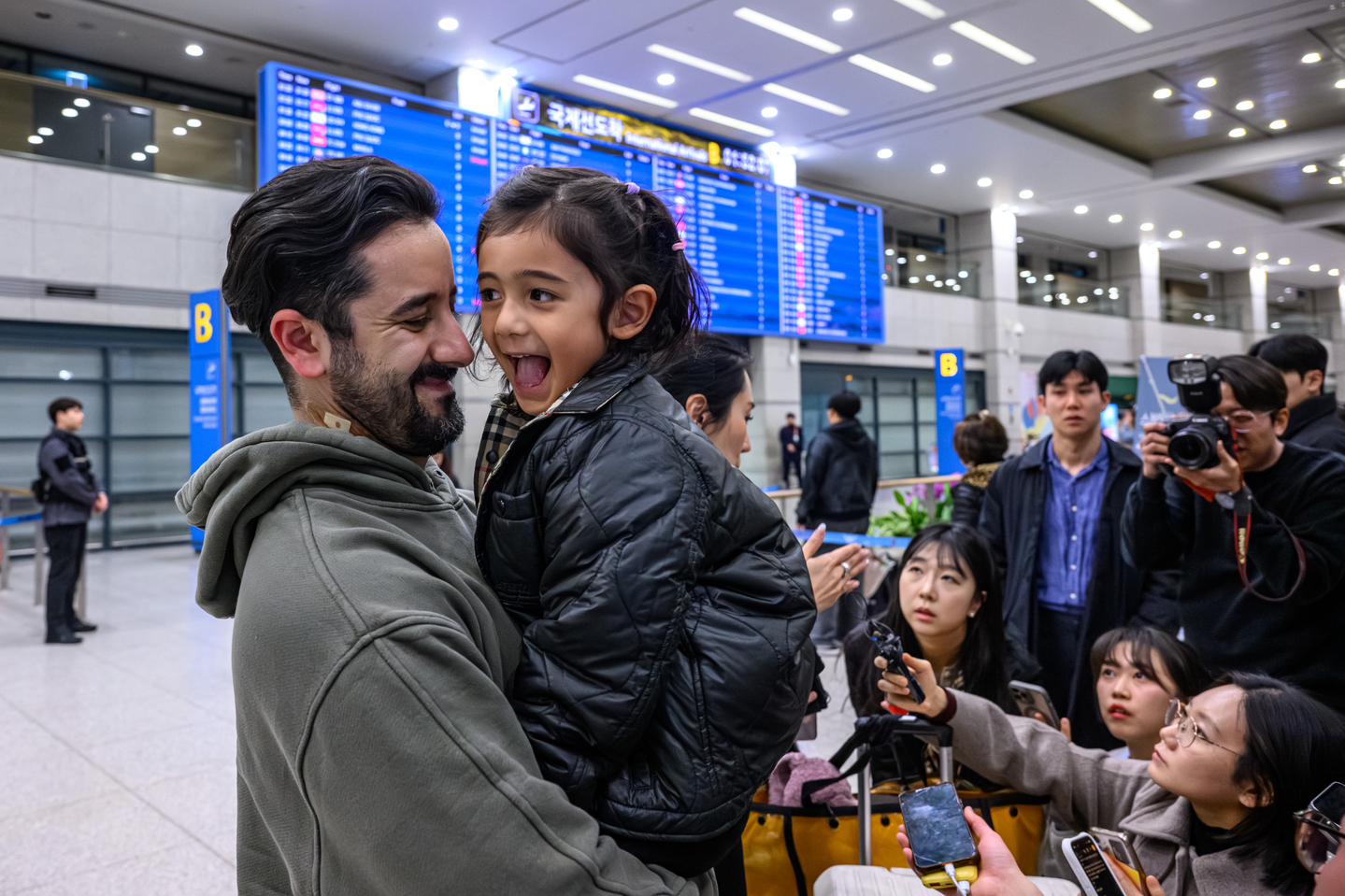 A father and daughter embrace each other at Incheon International Airport on March 9, after a chartered flight arranged by the Korean government landed in Korea. [KIM KYOUNG-ROK]