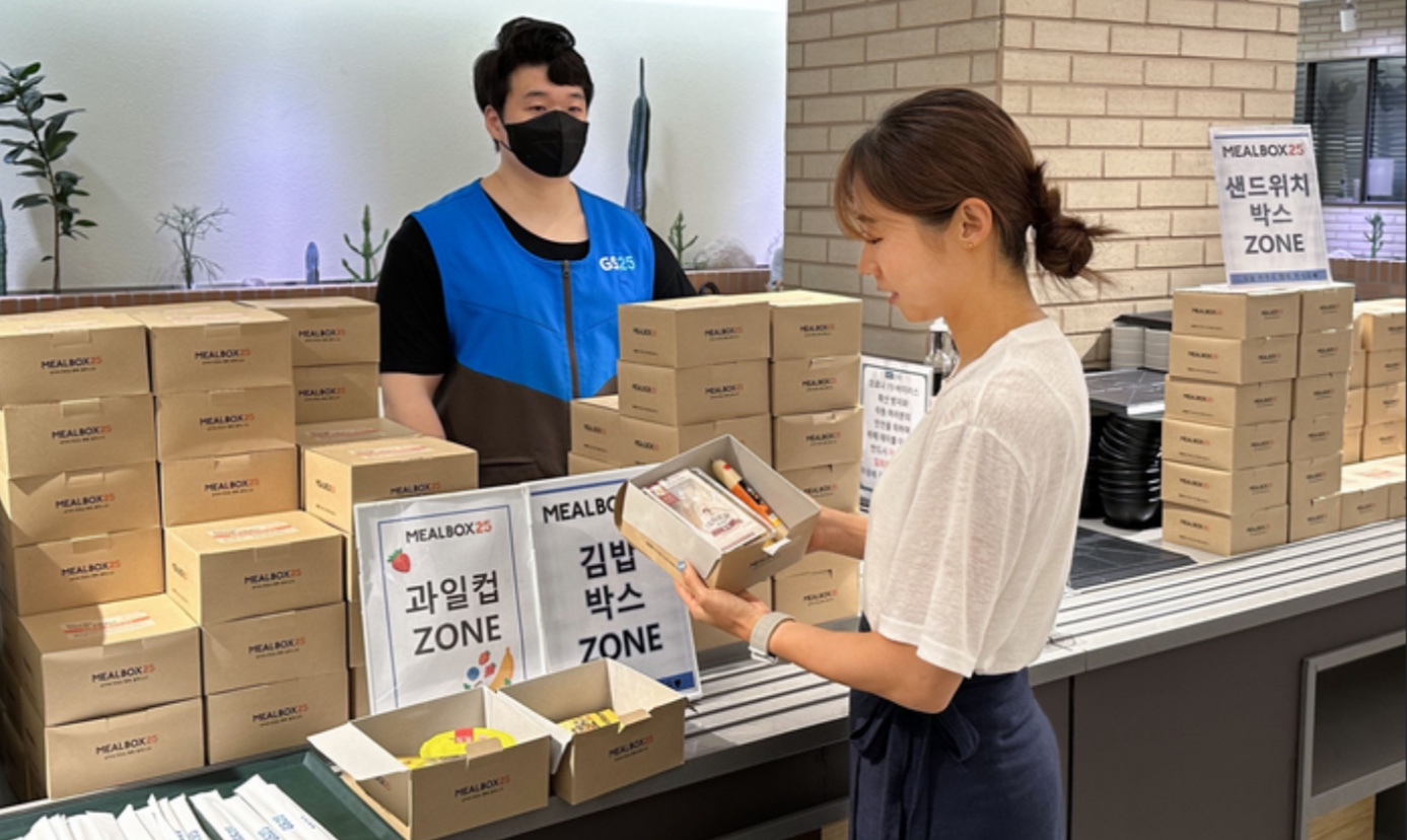 A customer examines products which are part of GS25's breakfast subscription service, ″Meal Box 25,″ at a GS25 store. [GS25]