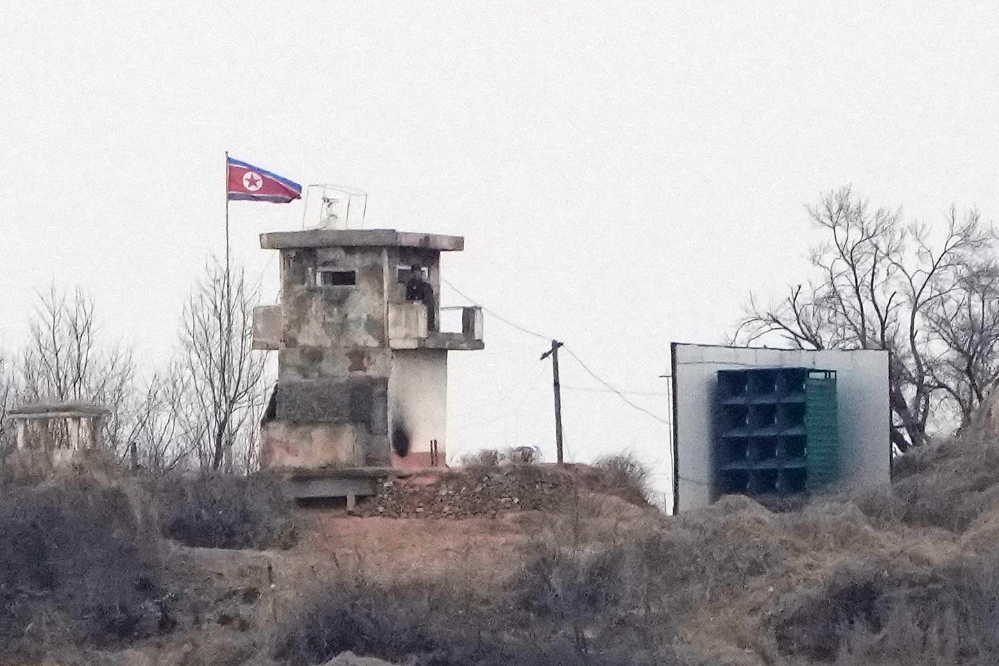 A soldier stands at a North Korean military guard post flying a national flag, seen from Paju, Gyeonggi on Feb. 26. [AP/YONHAP] 