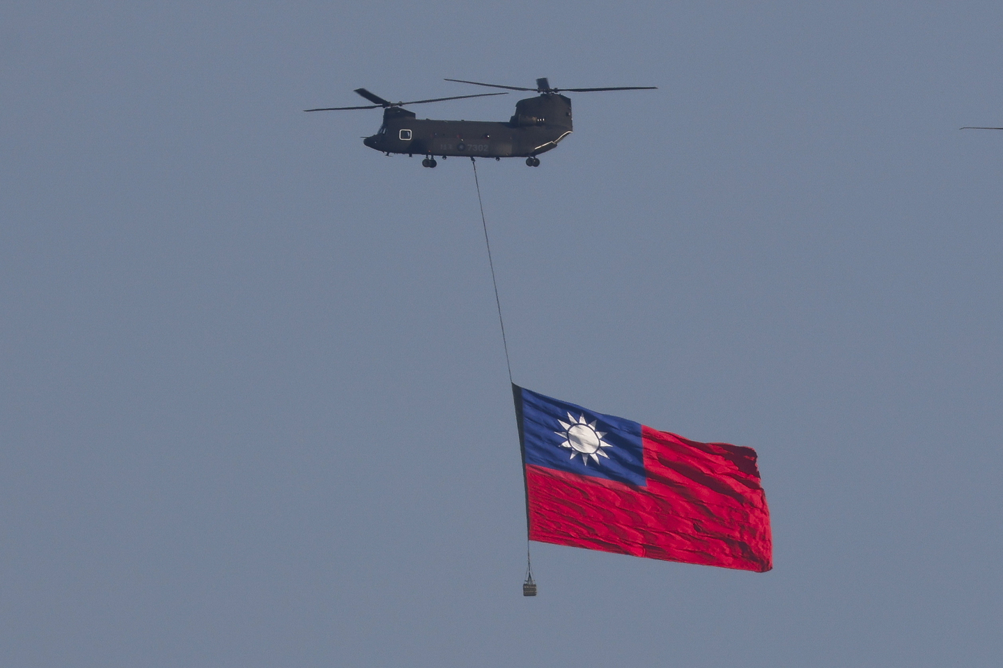 A CH-47SD Chinook transport helicopter hoists a giant Taiwan flag as it flies over downtown Taipei during a flag flyby rehearsal ahead of the country’s National Day in Taipei, Taiwan, on Oct. 8, 2025. [EPA/YONHAP] 