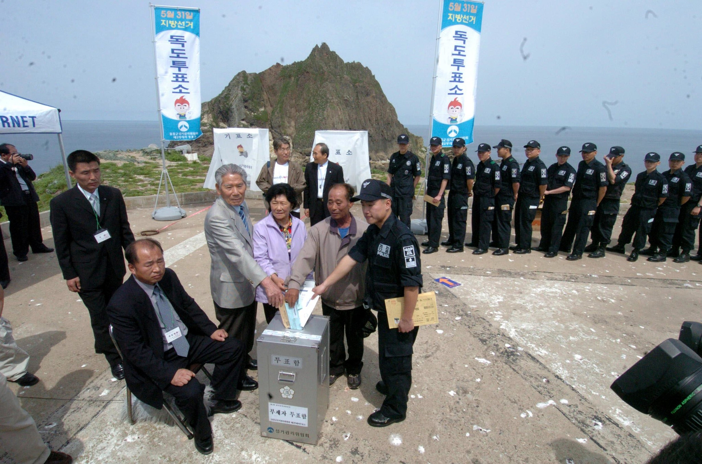 Voting takes place on Dokdo at an absentee polling station is set up in the first case of its kind in constitutional historyon May 25, 2006. Dokdo residents Kim Sung-do and Kim Sin-yeol cast their ballots with Seo Gi-jong, head of the Dokdo Volunteer Guards Veterans Association. [JOONGANG ILBO] 