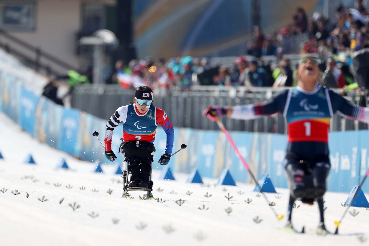 Kim Yun-ji, left, competes in the para cross-country skiing women's sprint sitting final at the 2026 Milan-Cortina Winter Paralympics at the Tesero Cross-Country Skiing Stadium in Italy on March 10. [KOREA PARALYMPIC COMMITTEE]