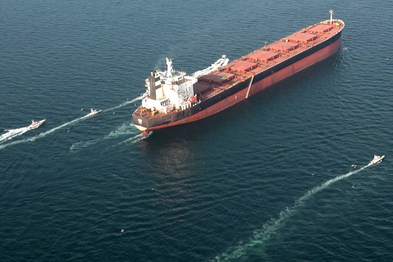 Boats maneuvering around a tanker vessel during a military exercise by Iran in the Strait of Hormuz. [AFP/YONHAP]