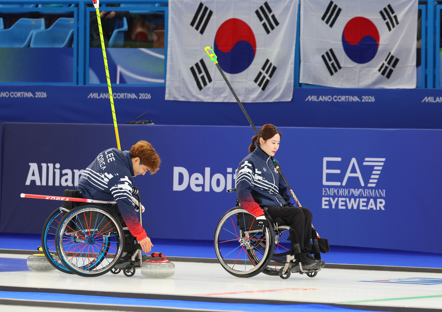 Korea’s Lee Yong-seok, left, and Baek Hye-jin pause to confer after the sixth end during the wheelchair curling mixed doubles semifinal against the United States at the 2026 Milan-Cortina Winter Paralympics at the Cortina Curling Olympic Stadium in Cortina, Italy, on March 10. [YONHAP]
