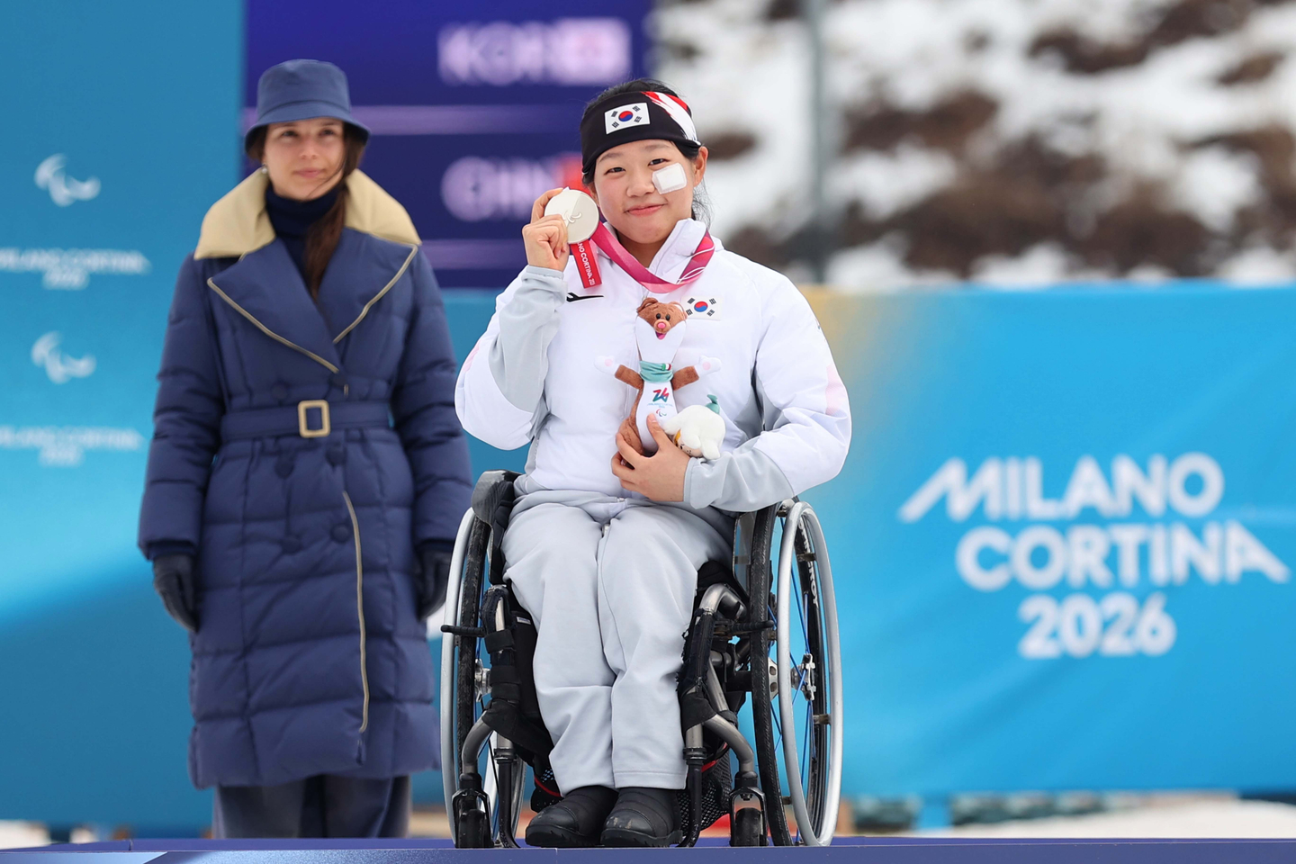 Kim Yun-ji, center, celebrates after winning the silver medal during the para cross-country skiing women's sprint sitting medal ceremony at the Tesero Cross-Country Stadium during the 2026 Milan-Cortina Winter Paralympics in Tesero, Italy, on March 10. [KOREA PARALYMPIC COMMITTEE]
