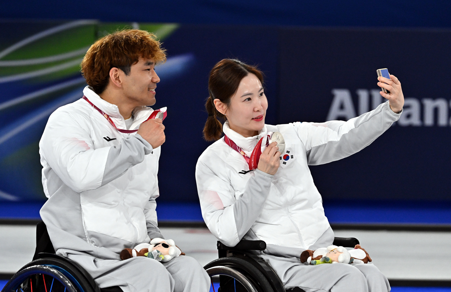 Lee Yong-seok, left, and Baek Hye-jin, who won silver in wheelchair curling mixed doubles at the 2026 Milan-Cortina Winter Paralympics, at the Cortina Curling Olympic Stadium in Cortina, Italy, pose for a selfie on March 11. [JOINT PRESS CORPS]