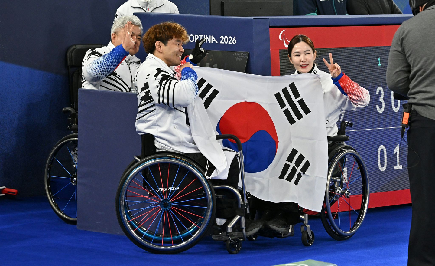 Lee Yong-seok, second to left, and Baek Hye-jin, right, who won silver in wheelchair curling mixed doubles at the 2026 Milan-Cortina Winter Paralympics, pose with coach Park Kil-woo at the Cortina Curling Olympic Stadium in Cortina, Italy, on March 11. [JOINT PRESS CORPS]