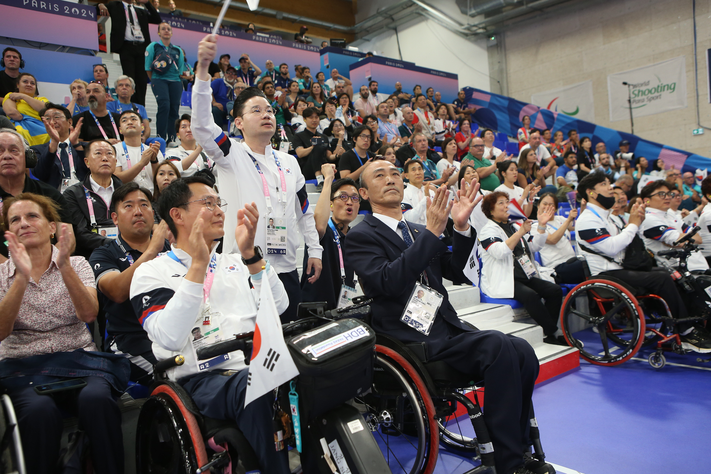 Bae Dong-hyun, head of the Korean delegation, and Korean supporters cheer for Kim Jung-nam. [KOREA PARALYMPIC COMMITTEE]