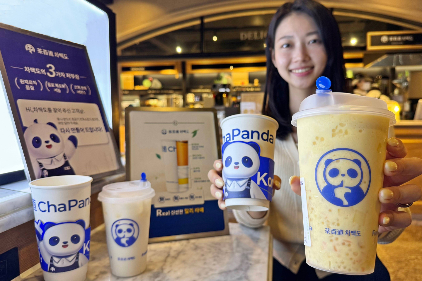 A model shows drinks by ChaPanda, a Chinese milk tea brand, at a pop-up shop at a Galleria Department Store in Seoul on April 22, 2024. [HANWHA GALLERIA]