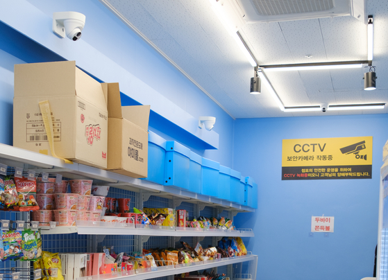 An unmanned store with multiple security cameras and a warning sign that security cameras are in operation. [CHO YONG-JUN]