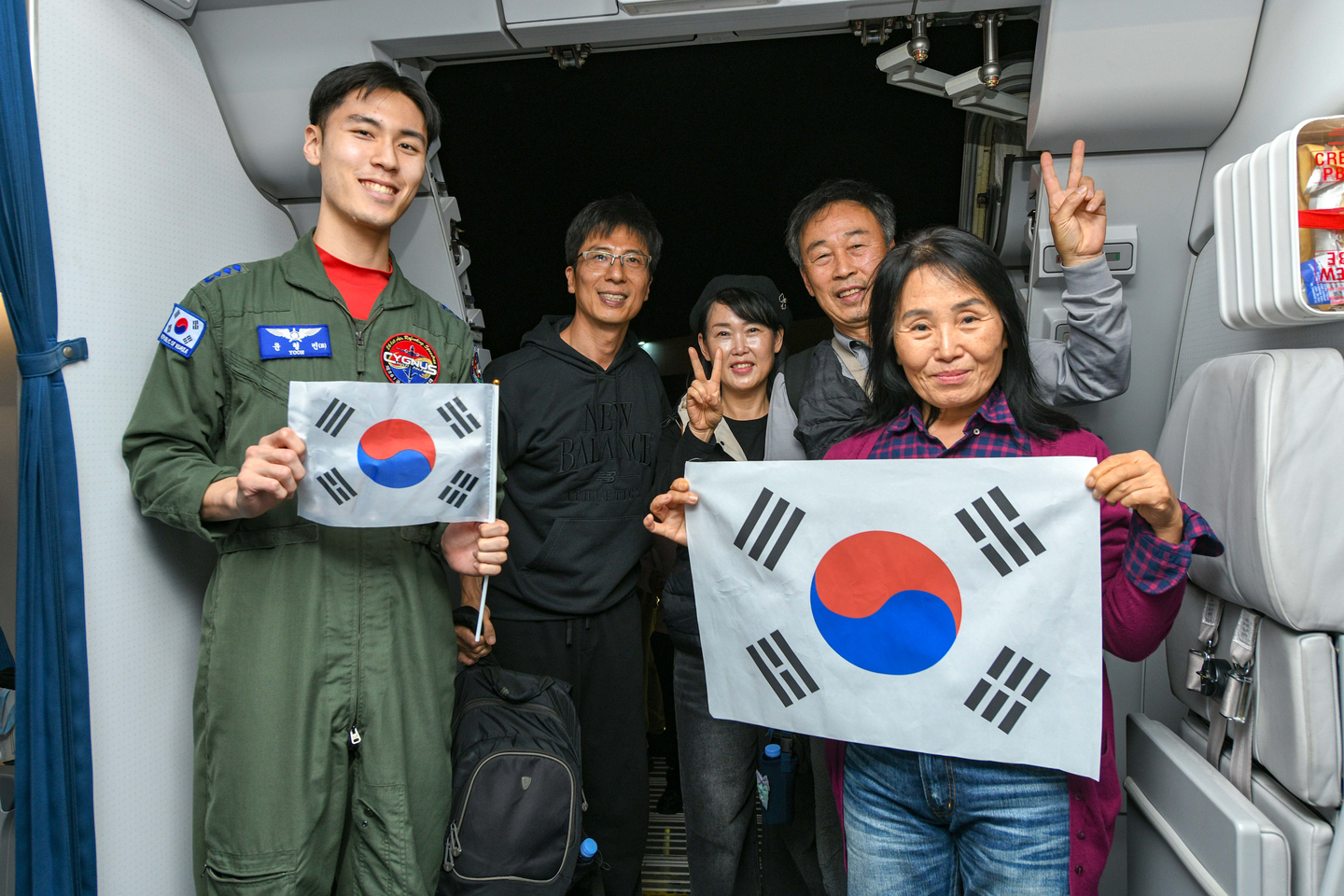 A Korean family poses with an Air Force officer aboard a military plane bringing them and more than 200 others home from Saudi Arabia on March 15. [YONHAP] 