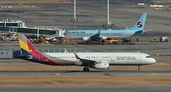 An Asiana Airlines passenger plane, front, taxis to the gate at Incheon International Airport on Jan. 13. [NEWS1]