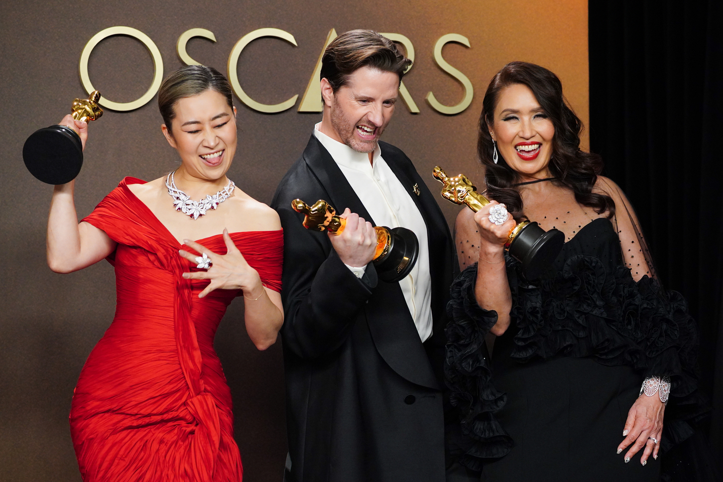 Maggie Kang, from left, Chris Appelhans, and Michelle L.M. Wong, winners of the award for animated feature film for Netflix's ″KPop Demon Hunters,″ pose in the press room at the Oscars on March 15, at the Dolby Theatre in Los Angeles. [AP/YONHAP]