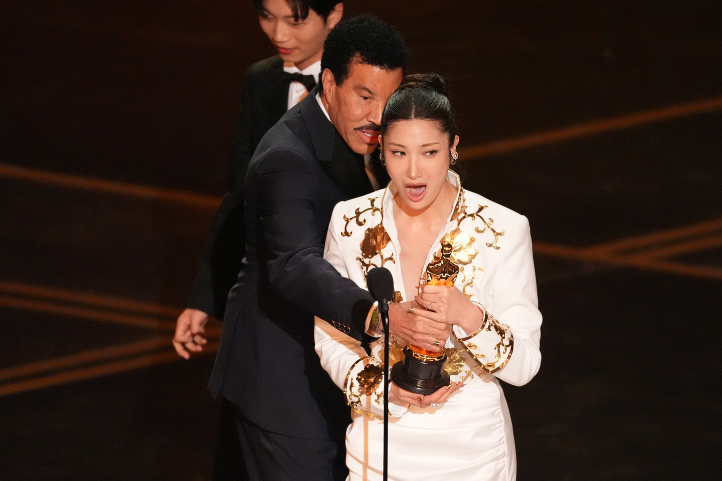 Lionel Richie, left, presents the award for best original song to EJAE for ″Golden″ (2025) from ″KPop Demon Hunters″ (2025) during the Oscars at the Dolby Theatre in Los Angeles on March 15. [AP/YONHAP]