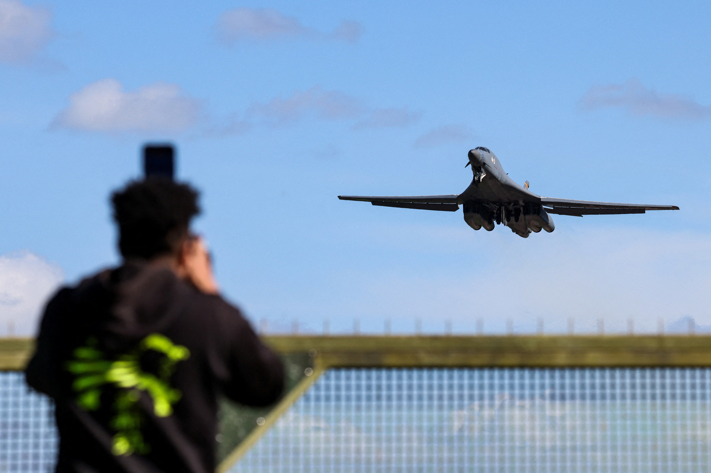 A plane spotter takes pictures as a USAF B-1 bomber takes off from RAF Fairford air base, used by United States Air Force personnel in Gloucestershire, Britain on March 14. [REUTERS/YONHAP]