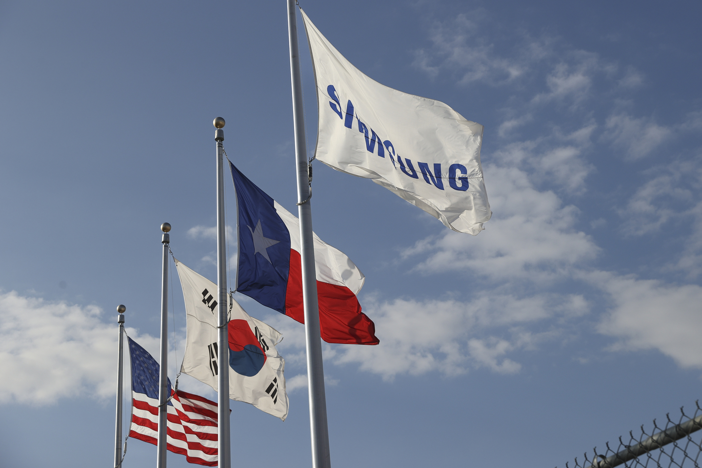  A Samsung, Texas, Korea, and United States flag hang in front of the Samsung semiconductor chip plant in Taylor, Texas, inJanuary 2024. [EPA/YONHAP]