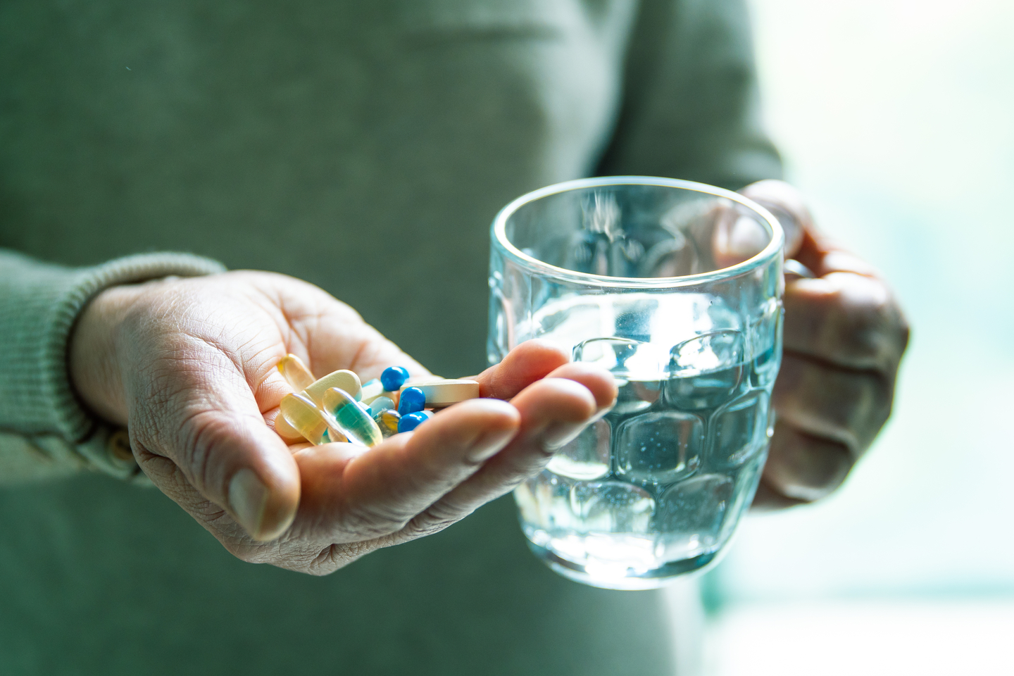 A person holds pills in one hand. [ASAN MEDICAL CENTER]