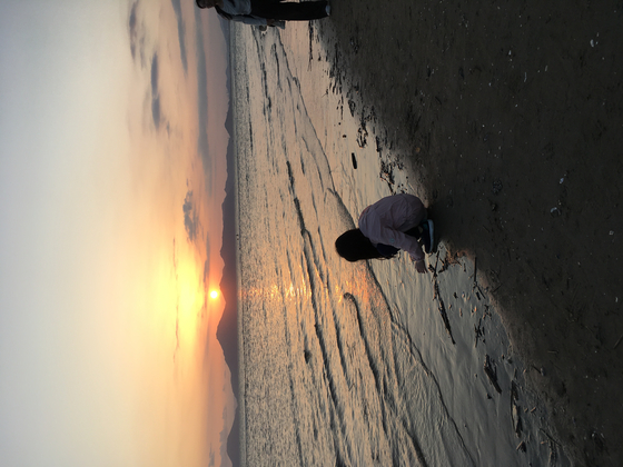 Me when I was in first grade, touching seawater in front of a sunset in Dadaepo Beach. [LEE EUNJAE]