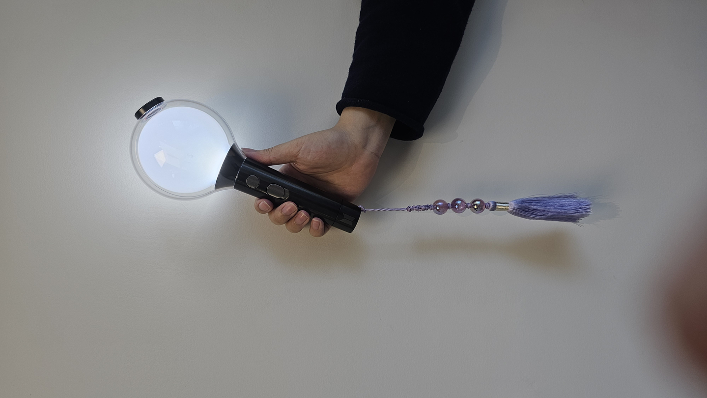 BTS's official ARMY Bomb light stick with a purple "norigae," a traditional Korean ornament [SHIN HA-NEE]