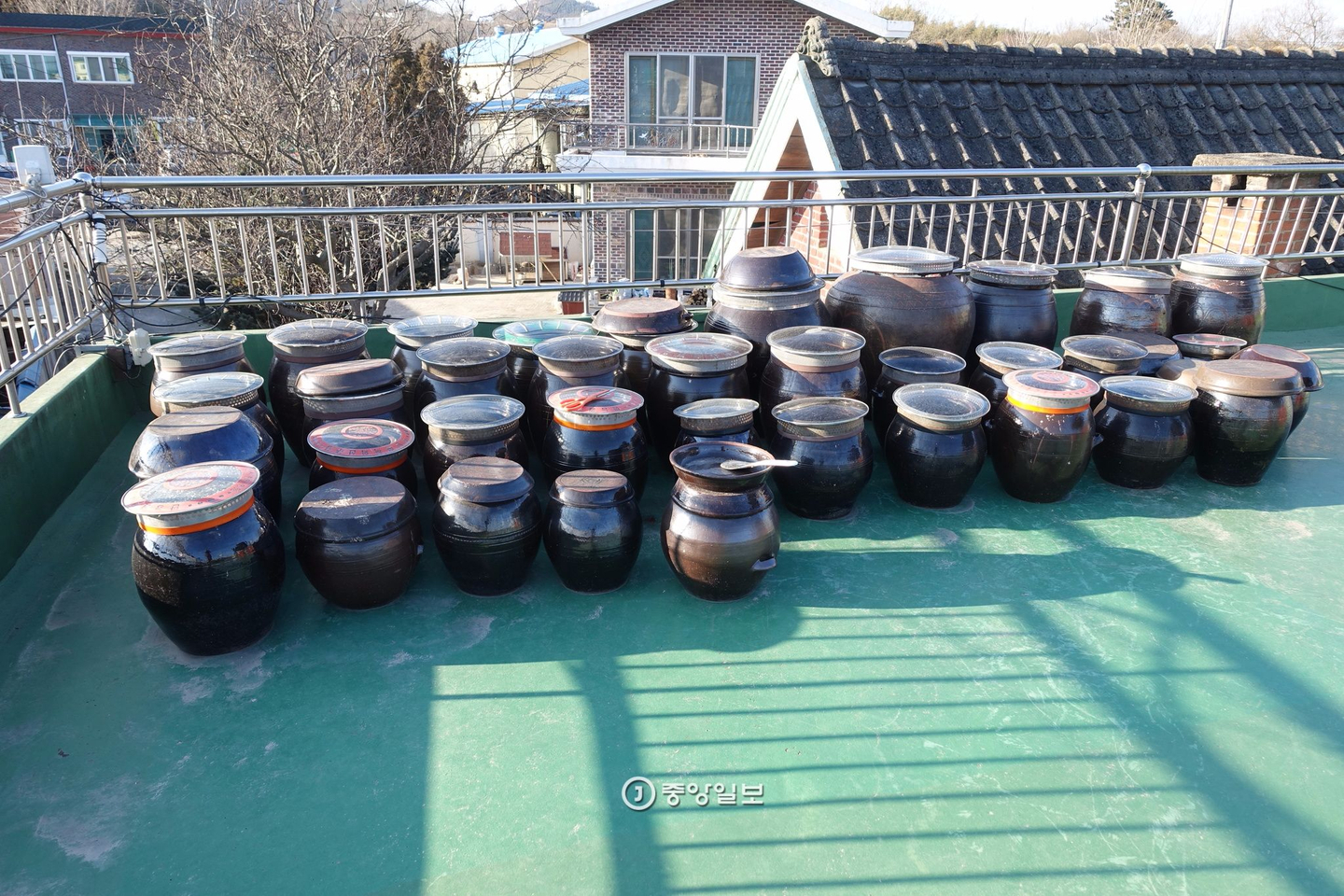 A traditional restaurant owner's jangdokdae, a platform of earthenware jars used for fermenting sauces, set up on the rooftop of his home. Until the 1970s, nearly every household in Korea kept such jars somewhere in or around the home to make gochujang, doenjang (fermented bean paste) and soy sauce. [JOONGANG ILBO]